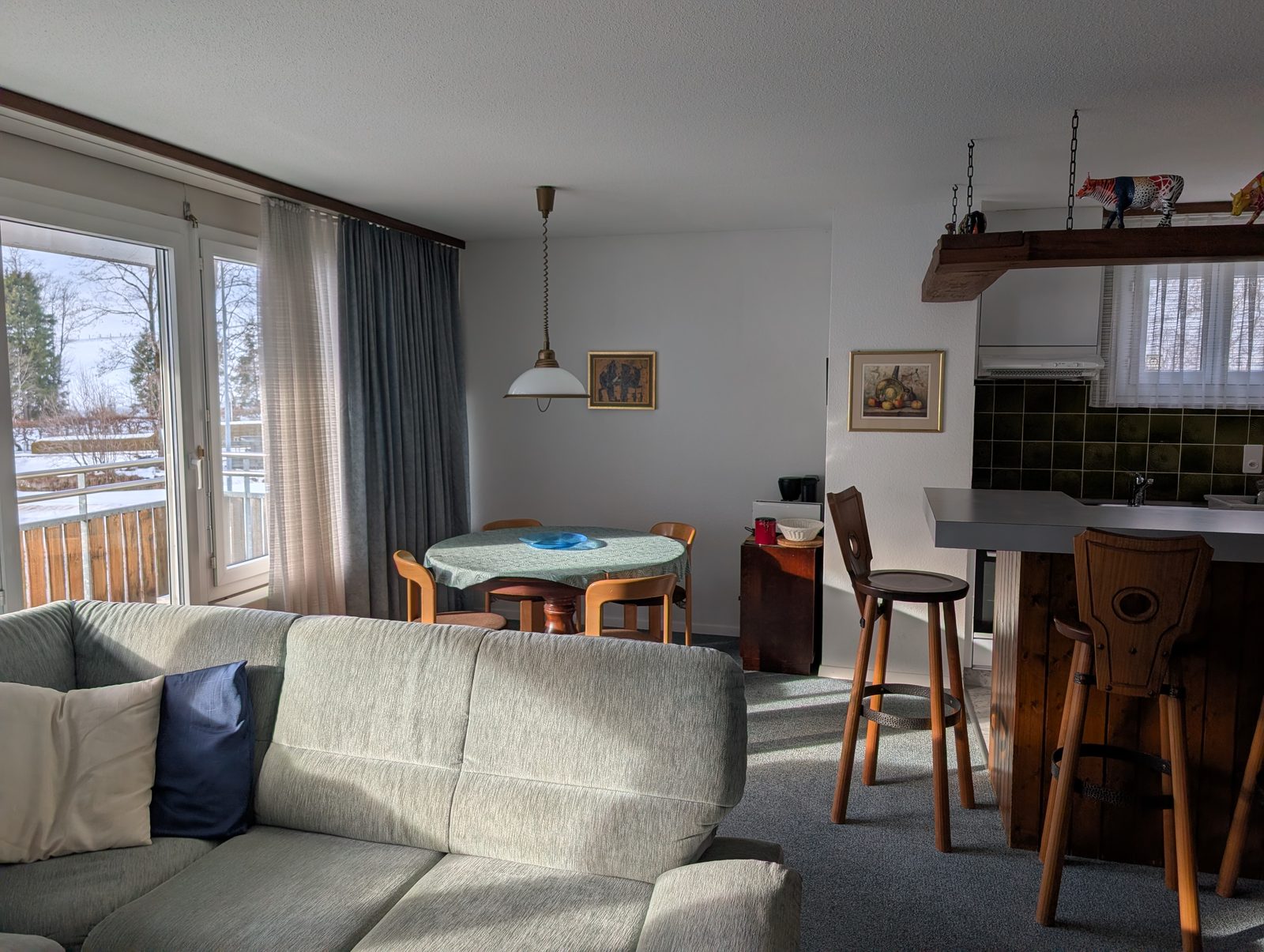 Helles Wohnzimmer mit Schlafcouch und Essbereich